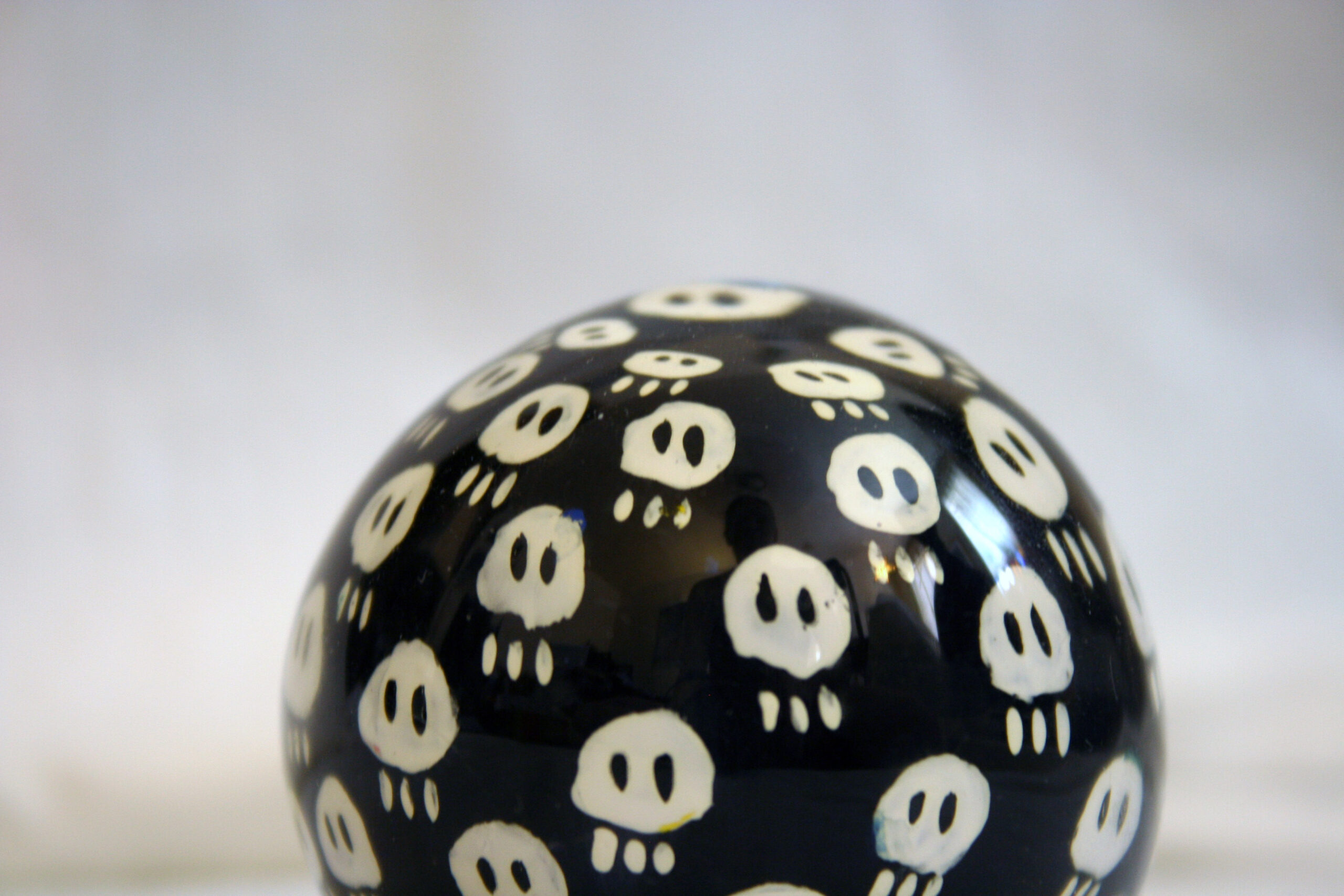 Blown Glass paperweight with hand painted cartoon skulls on it